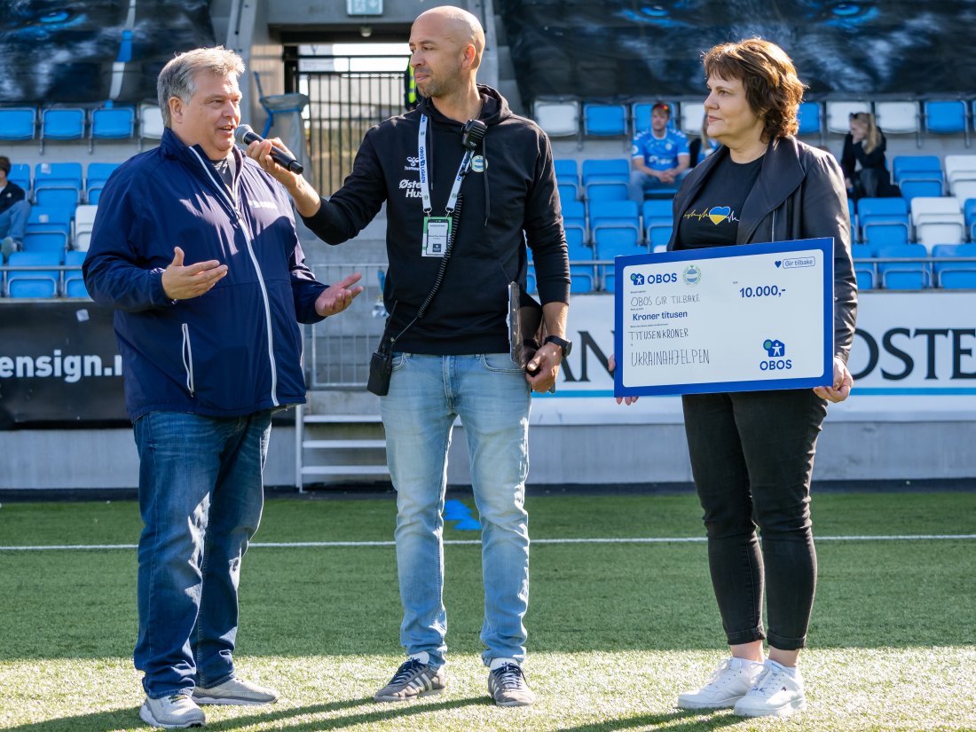 Til venstre: Sponsoransvarlig i OBOS, Eddie Christopher Thomas som her deler ut 10.000 til Ukraina-hjelpen i pausen mot Vålerenga. (Foto Nanco Hoogstad)